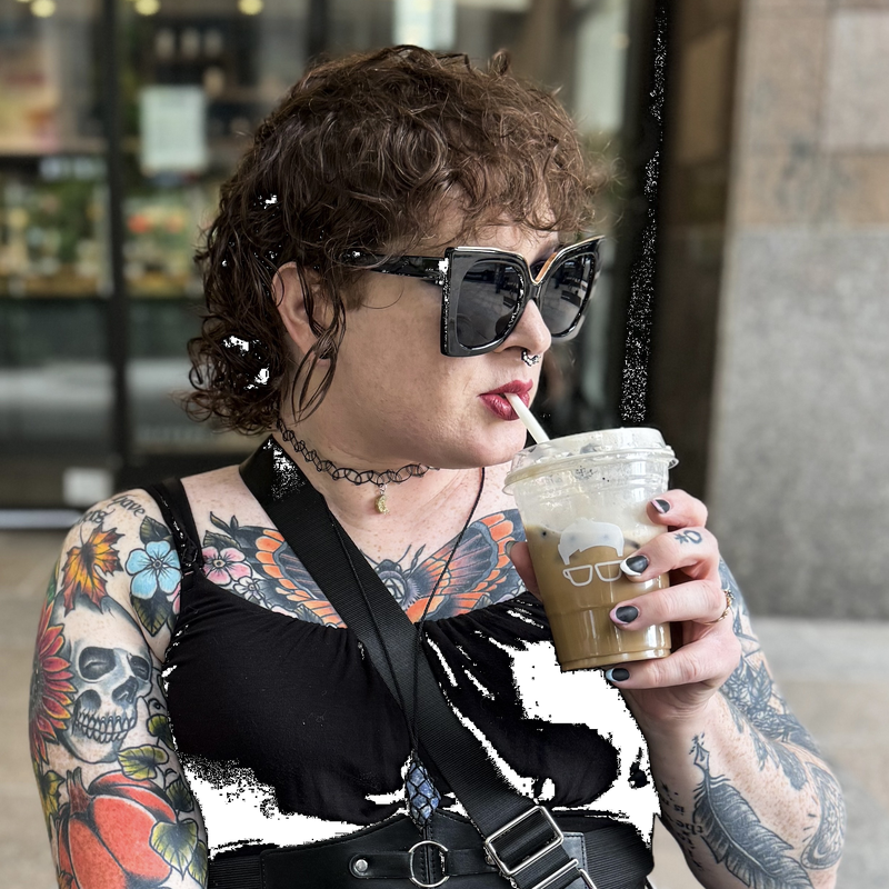 a photo of parker lee drinking an iced latte in front of a coffee shop.